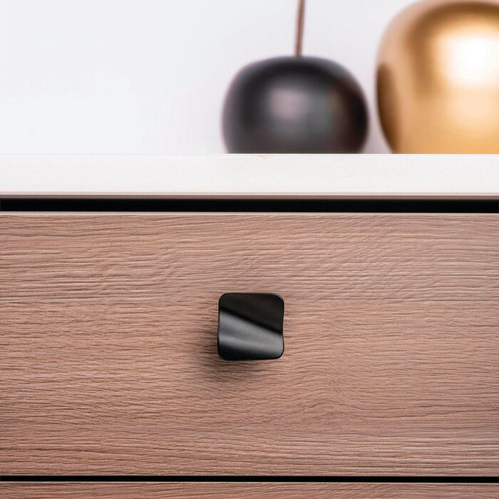 Poignée de meuble noir mat modèle vague REI installée sur un tiroir de meuble